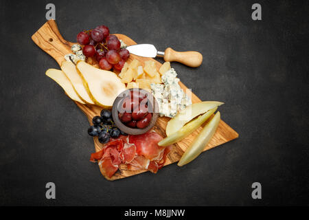Meat plate antipasti snack - Prosciutto ham, blue cheese, melon, grapes, Olives Stock Photo