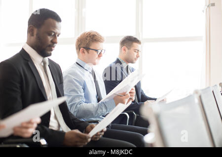 Men reading papers Stock Photo