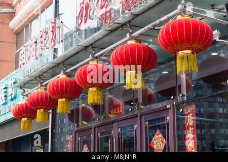 Hunchun, Jilin, China - March 8, 2018: Red round Chinese traditional paper lantern lamp shades against the background of the entrance to the building Stock Photo