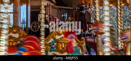 Traditional victorian steam powered colourful carousel fairground attraction fastly rotating at the fun filled funfare Stock Photo