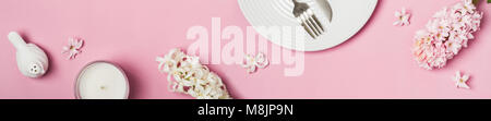 Spring flowers banner. Hyacinths and tableware on a pink background. Stock Photo