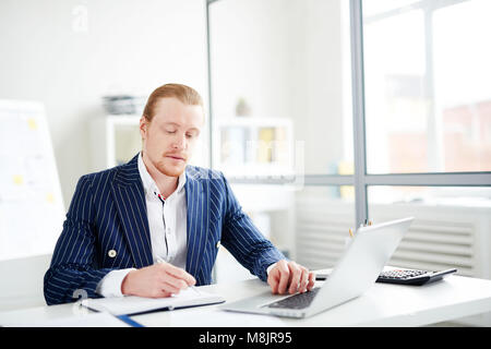 Young serious manager busy with his work Stock Photo