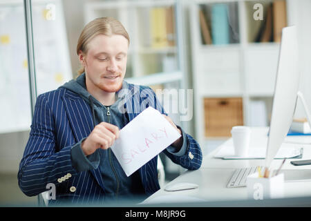 Businessman getting salary in envelope at office Stock Photo