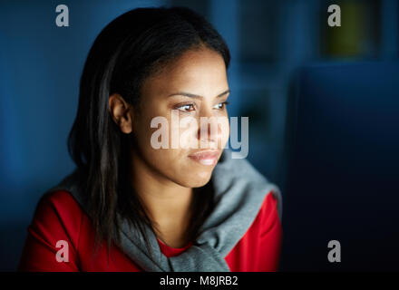 Young businesswoman working on computer at office till night Stock Photo