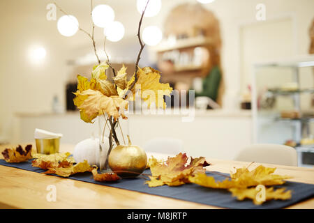 Autumn bouquet in the vase standing on the table. And leaves decorating table Stock Photo