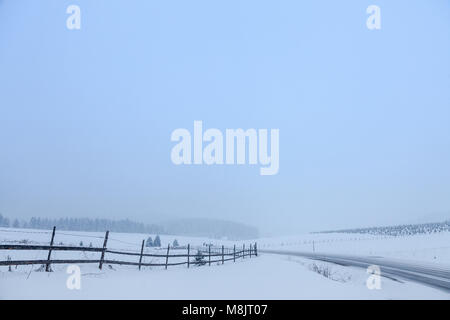 Road covered in snow in the Bosnian mountains at sunset, during a heavy winter condition  Picture of a deserted road covered in snow during winter in  Stock Photo