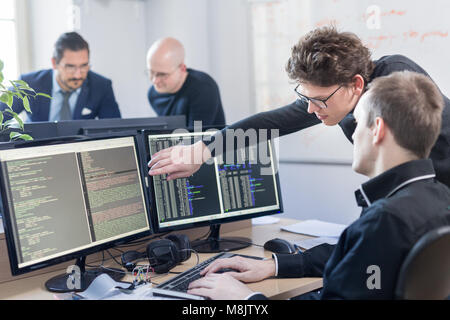 Startup business problem solving. Software developers working on desktop computer. Stock Photo
