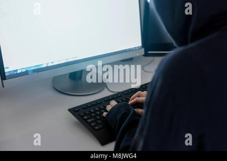 anonymous hacker in the hoodie, breaks the access to steal information and infect computers and systems. the concept of hacking and cyber war Stock Photo