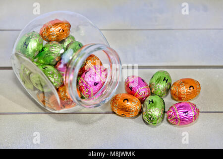 various colored chocolate Easter eggs on a wooden surface Stock Photo