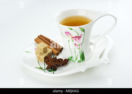 Cup of tea with sugar cubes,  cinnamon sticks and star anise isolated on white background Stock Photo