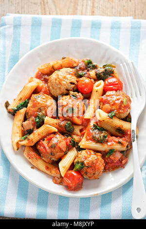 Pork meatballs with pasta, cherry tomatoes, spinach in tomato sauce