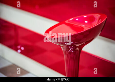 Red plastic bar stool near counter Stock Photo