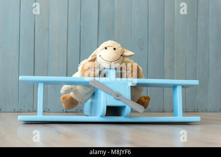 Wooden retro airplane model and sheep toy over retro vintage brown background. Toys from wood Stock Photo