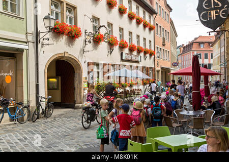 Street scene in Bamberg, Germany lined with outdoor cafes and restaurants. Showing common daily activities of locals and tourists. Stock Photo