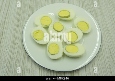 Hard boiled eggs, sliced in halves on wooden background Stock Photo