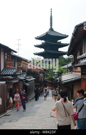 Visitors and tourists walk at the traditional Kyoto street at well-known Gion, Higashiyama District. Yasaka Shrine in the background. Stock Photo