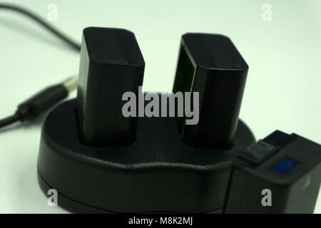 Lithium battery and charger for digital photo cameras on isolated white background Stock Photo