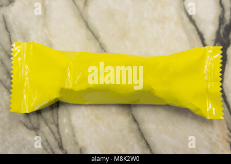 Yellow blank sealed plastic foil pouch food bag snack packaging isolated on white background flat top view Stock Photo