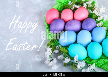 Colored Easter eggs with white flowers on a gray concrete background Stock Photo