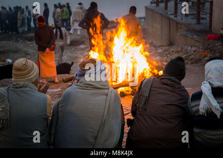 People look at the funeral pyre that night. The ceremony of the cremation of Manikarnika Ghat on the banks of the Ganges river in Varanasi, India. Stock Photo