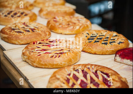 Different types of pies in pastry shop on the wooden display. Selective focus, space for text. Stock Photo