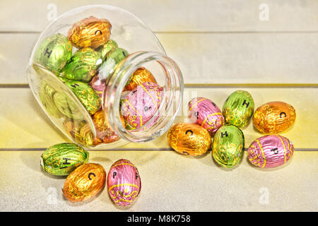 various colored chocolate Easter eggs on a wooden surface Stock Photo