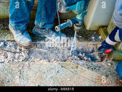 Workers perform small excavation work with tools during new fiber optic construction work. closeup with blurred motion Stock Photo