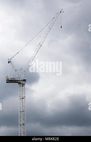 Mechanic crane for construction with grey cloudy sky in london, wembley near the stadium building Stock Photo