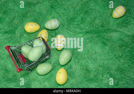 Buying a easter eggs from supermarket, Ester eggs in shopping cart on grass Stock Photo