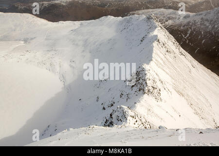 Looking down to Striding Edge on Helvellyn, Lake District, UK with a frozen, snow covered Red Tarn. Stock Photo