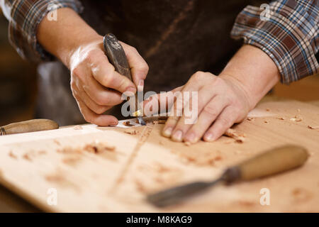 Carpenter with chisel in the hands on the workbench. Vintage Stock Photo