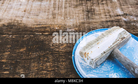 Retro brush for whitewashing walls on a wooden oak board, toning, place for text Stock Photo