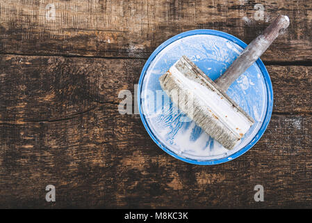 Retro brush for whitewashing walls on a wooden oak board, toning, place for text Stock Photo