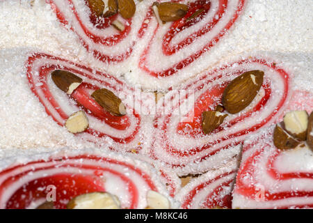 background - rolls of rahat lokum in featuring dried coconut chips with almond nuts Stock Photo