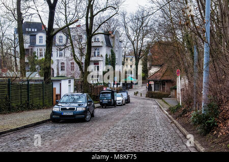 Berlin-Grunewald Street view with cobbled road, historic old apartment buildings,red tiled roof of S-bahn station Stock Photo