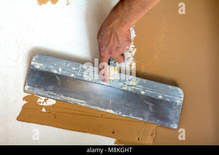 Renovation workers hand plastering the wall Stock Photo