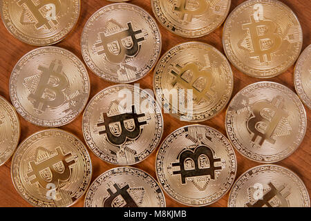 several golden bitcoins on top of wooden table. Stock Photo