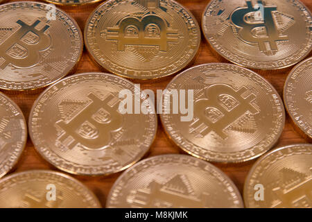 several golden bitcoins on top of wooden table. Stock Photo