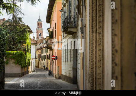 A quiet residential back street in the centre of Crema, Italy, with a church tower on its axis. Stock Photo