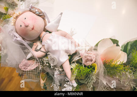 Dolls in national castes and a bouquet of flowers stand on the stairs in the interior Stock Photo