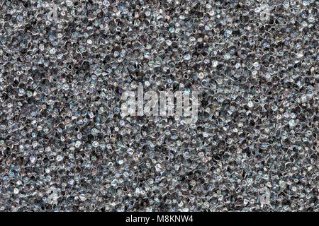 Close-up black  polyurethane foam texture. Rainbow film flares. Abstract black cellular background Stock Photo