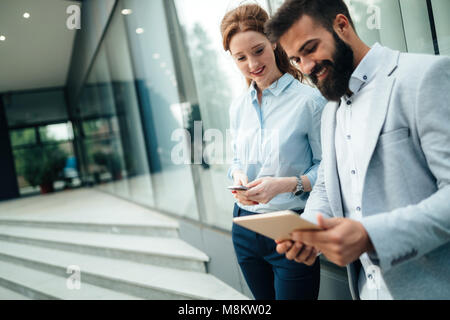 Business couple using digital tablet in front of office Stock Photo