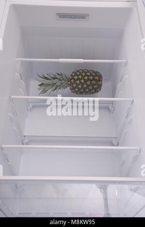 Pineapple inside in empty clean refrigerator with opened door Stock Photo