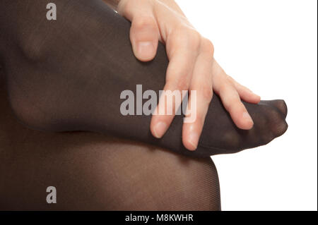 Close-up of female foot with pantyhose. Woman is rubbing her toes to relax pain. Stock Photo