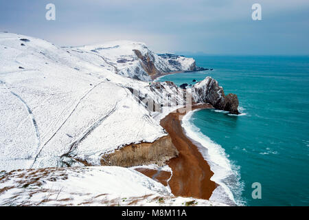 Lulworth, Dorset, UK.  18th March 2018.  UK Weather.  Durdle Door on the Jurassic Coast of Dorset with a covering of snow after a morning of heavy wintery showers.  Picture Credit: Graham Hunt/Alamy Live News. Stock Photo