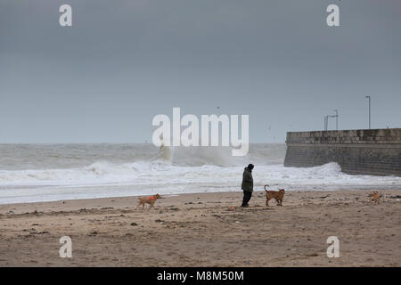 Ramsgate, Kent, UK 18th March, 2018 man and two dogs walk on the beach in a storm. Sue Holness Credit: Sue Holness/Alamy Live News Stock Photo