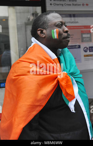 London, UK. 18th March, 2018. An Afro-Caribbean    man wearing an Irish Tricolour watching the annual St Patrick’s day parade in Central London, England, United Kingdom.   Credit: Michael Preston/Alamy Live News Stock Photo