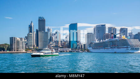 harbourside view of Sydney Cove with Circular Quay, the Sydney city skyline, Supercat ferry Susie O'Neill and cruise ship Carnival Spirit moored at th Stock Photo