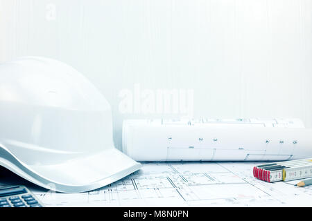 protective helmet, folding ruler, calculator, pencil on contractor workplace table. construction background.  Stock Photo