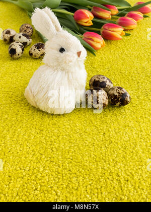 Easter Eggs, Easter Bunny and Tulips on Lime Green Background with Copy Space. Stock Photo